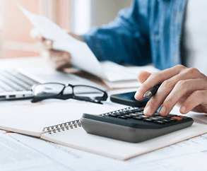 Persoon rekent met rekenmachine en documenten